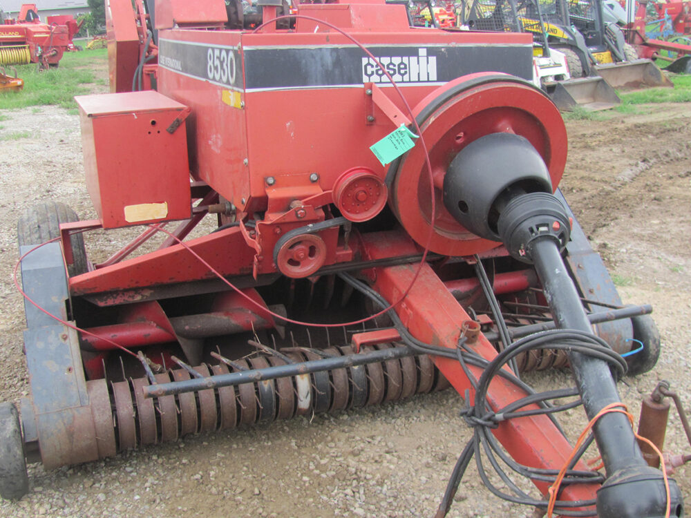 Used Case IH 8530 inline baler with thrower, missing pickup teeth, and a rusted PTO shaft that won’t move, in good condition.