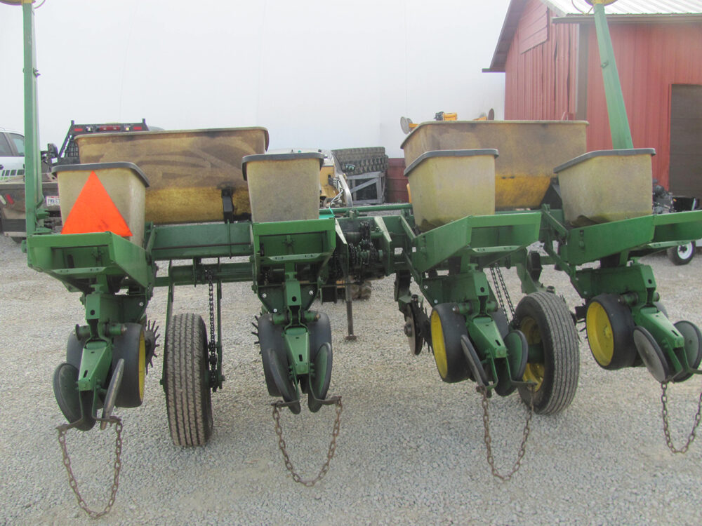 Used John Deere 4-row corn planter, conventional with row cleaners, dry fertilizer hoppers, hydraulic lift, in good condition but missing fertilizer hopper lids.