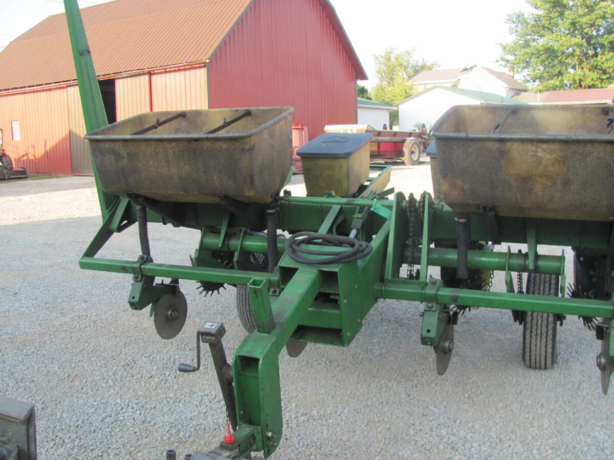 Used John Deere 4-row corn planter, conventional with row cleaners, dry fertilizer hoppers, hydraulic lift, in good condition but missing fertilizer hopper lids.
