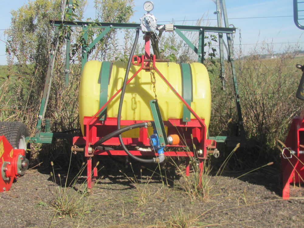 Used Boontown 55-Gallon Sprayer with 21' booms, 3-point hitch, 6-roller PTO-driven pump, in good condition.