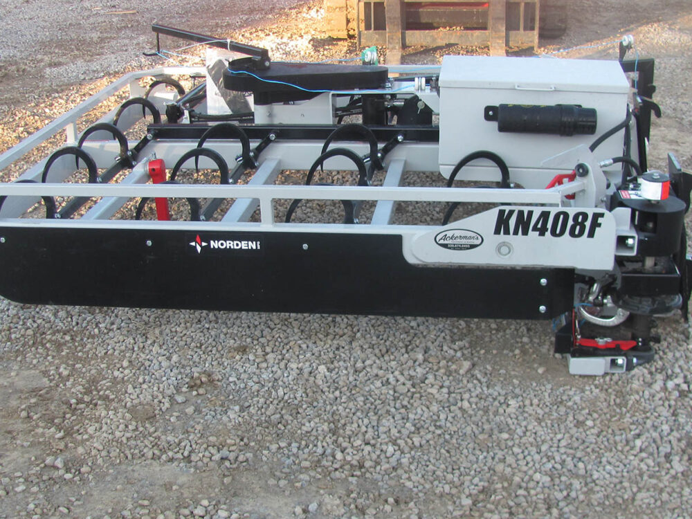 Used Norden KN408F 8-bale flat tie grabber with flat-face hydraulics, requires 1,700-lb lift capacity, fits JD 540R model loader, serial number G257966.