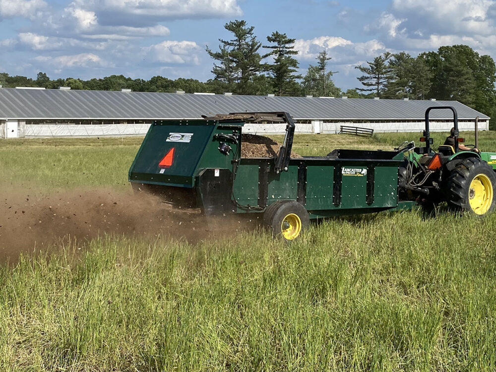 New 200-bushel Lancaster manure spreader with PTO drive, air tires, 2-wheel design, commercial bed liner, 3-beater system, tailgate, and fertilizer spinners.