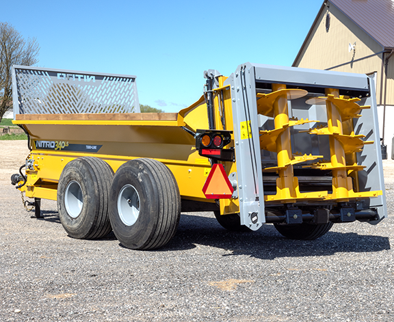 Used Tubeline 550 manure spreader with tandem flotation tires, manual flow control, gate indicator, light kit, flanged paddle kit, 8-ton carrying capacity, and 24.5' length.
