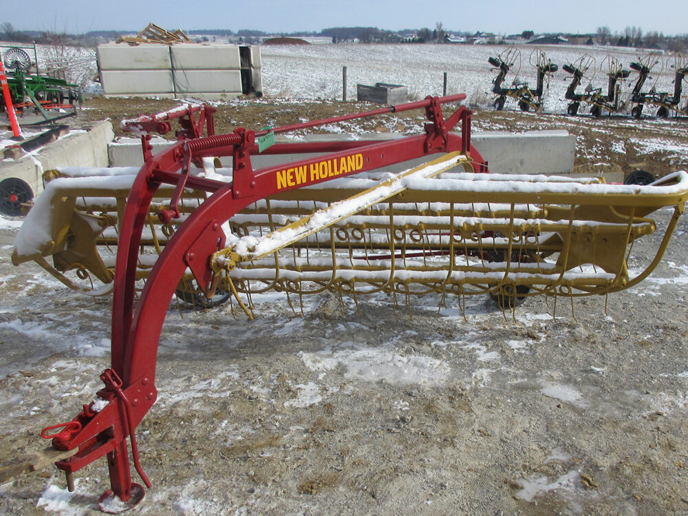Used New Holland 256 Rolabar rake with steel wheels, field ready, painted, and serial #423260.
