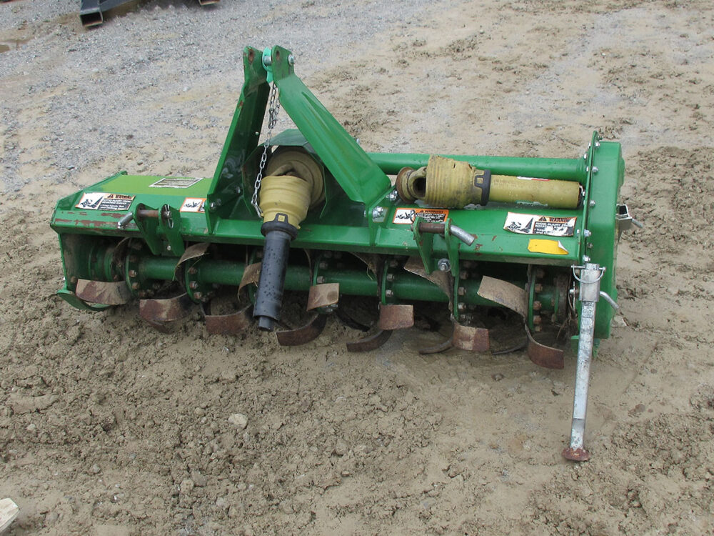 Used John Deere 655 tiller with 47" cutting width, 7" tilling depth, 14.5" tine cutting diameter, 239 RPM tine shaft speed, adjustable skid shoes from 1.2"–3", 401 lb weight, new in 2020 and only used twice, stored inside barn, and serial #1LV0655BEJ0120827.